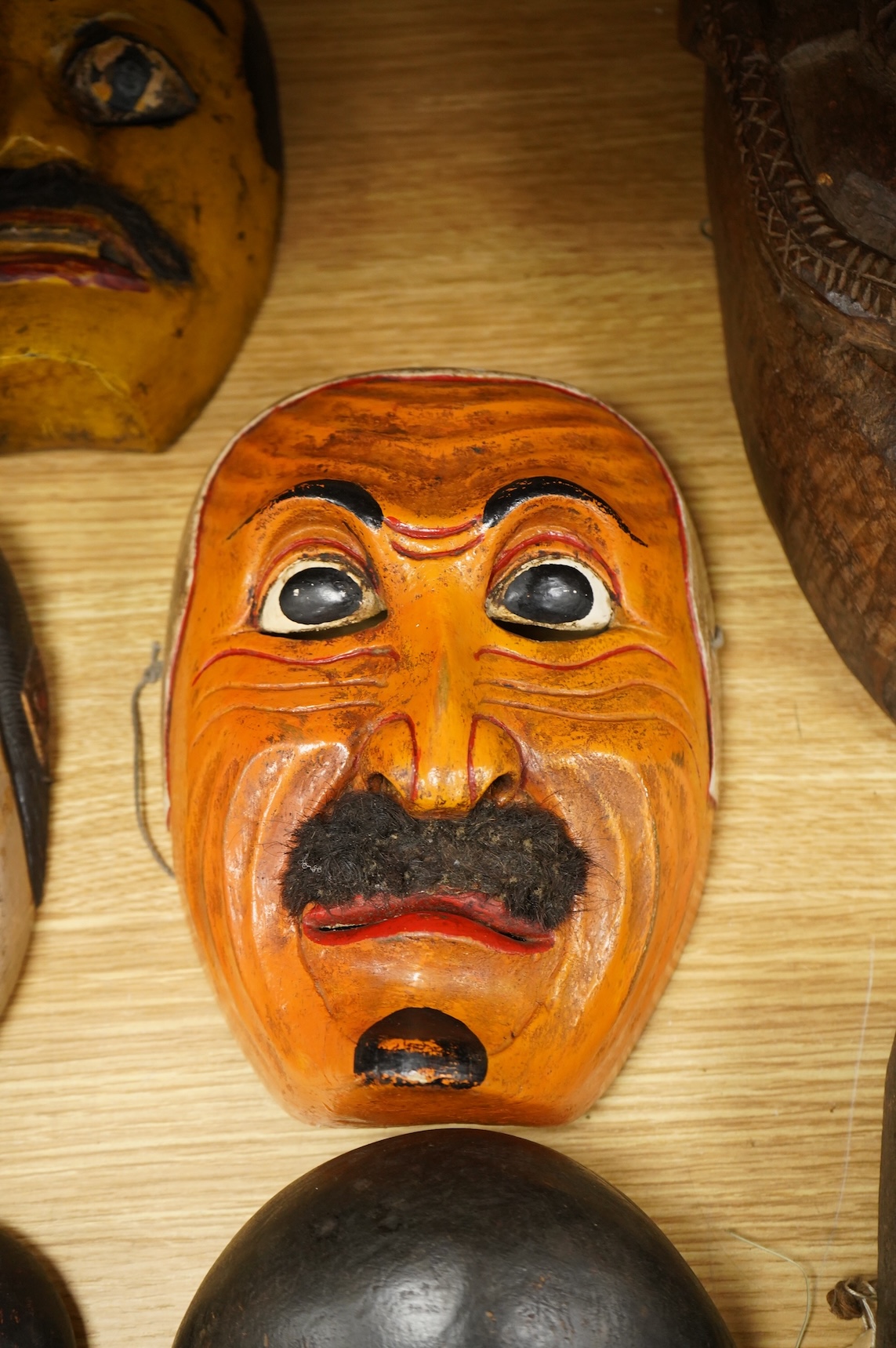 A collection of seven Nepalese, African and Indonesian masks to include a Magar example and one from the Dan Tribe, Liberia, largest 40cm